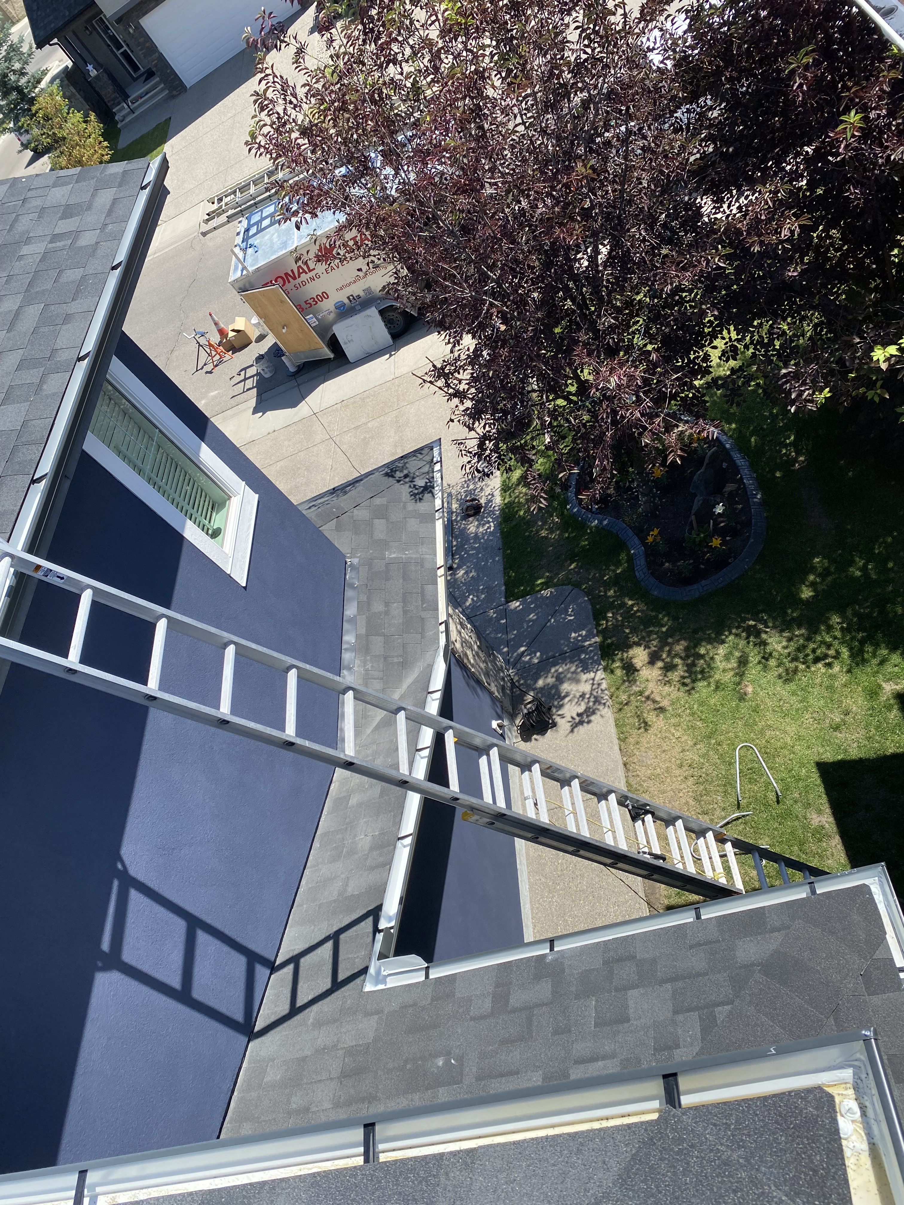Eavestrough installed along rooftop with backyard view