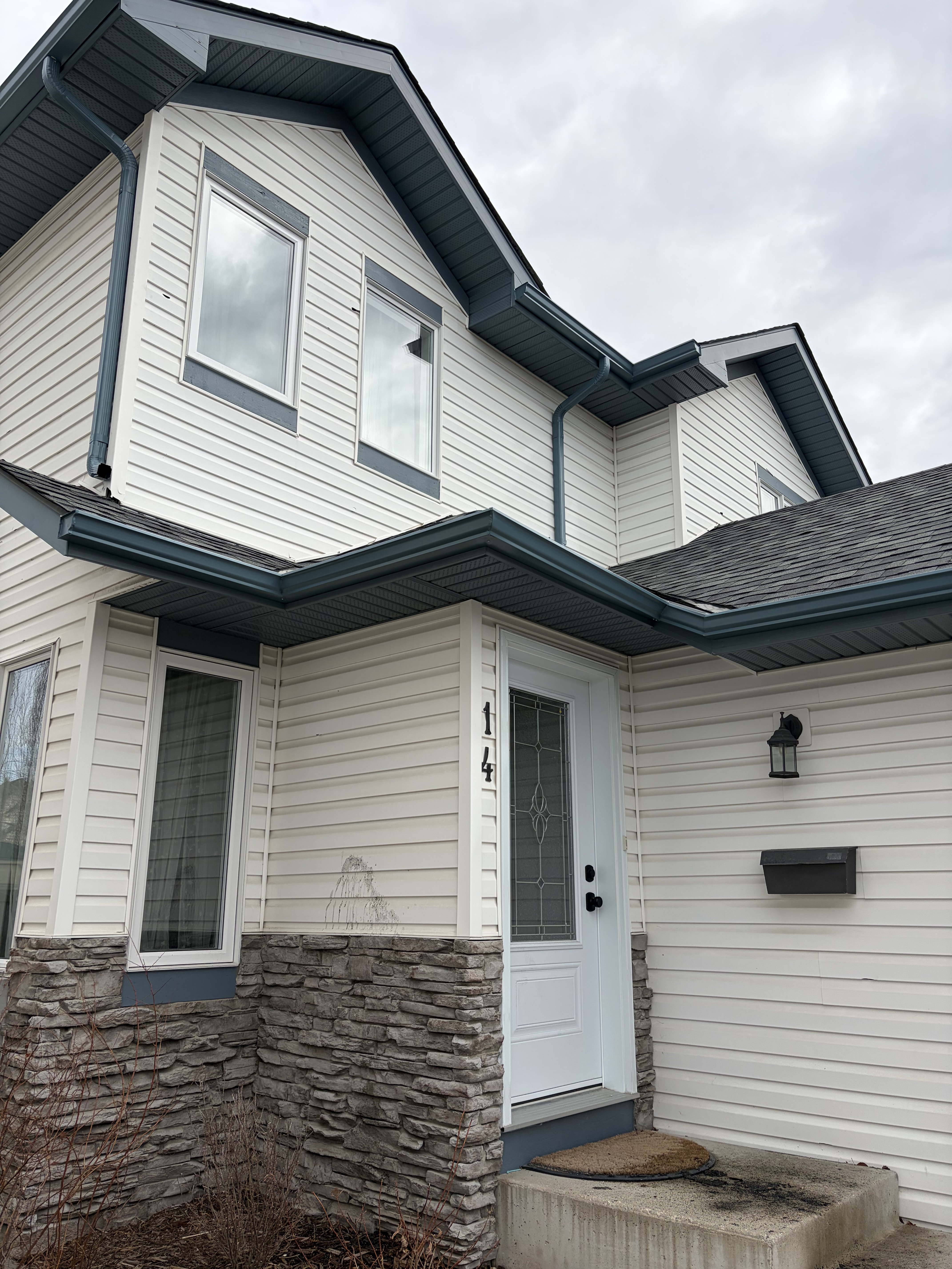 Home with vinyl siding and stone accent