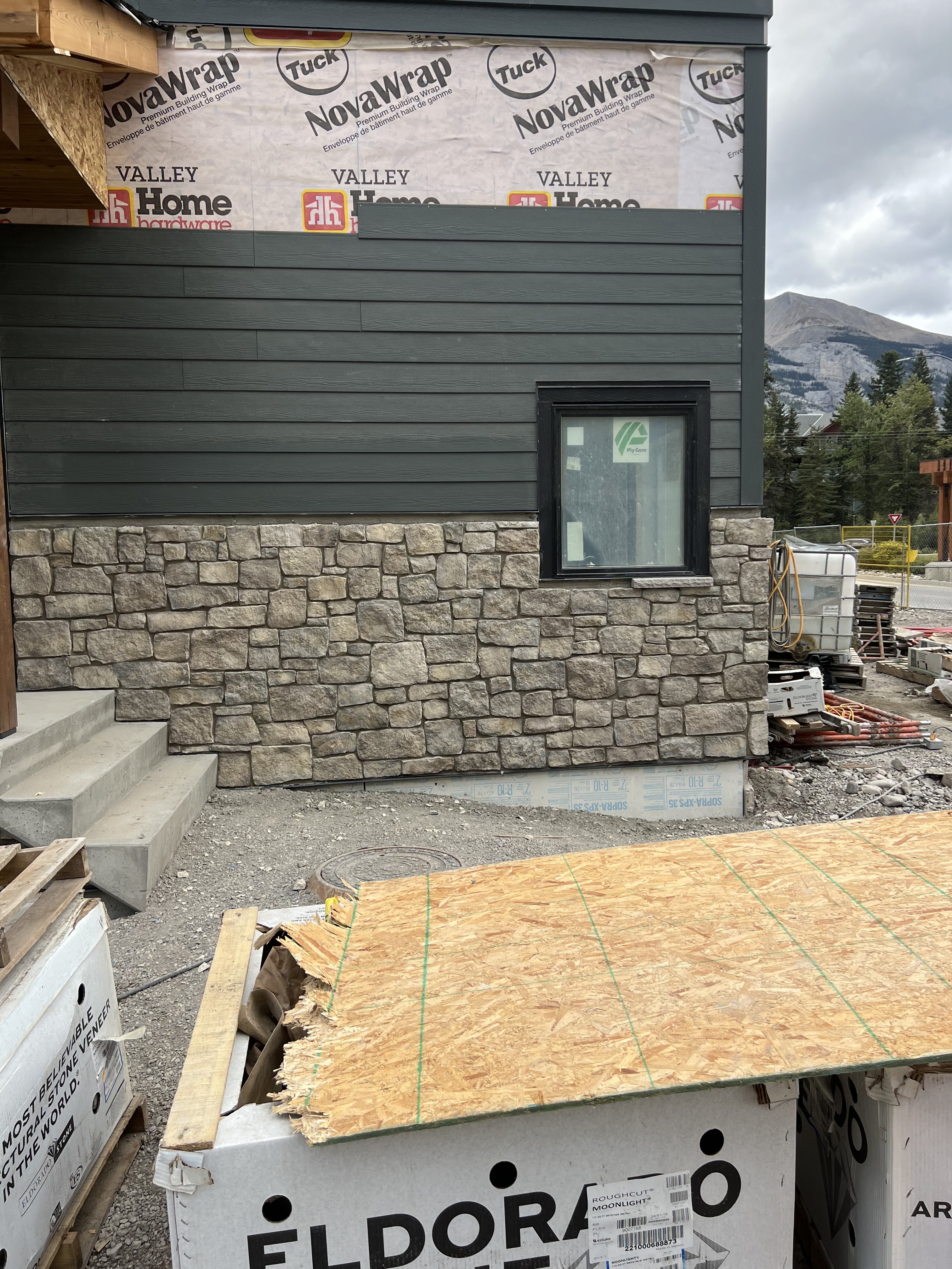 Manufactured stone veneer installation against dark siding