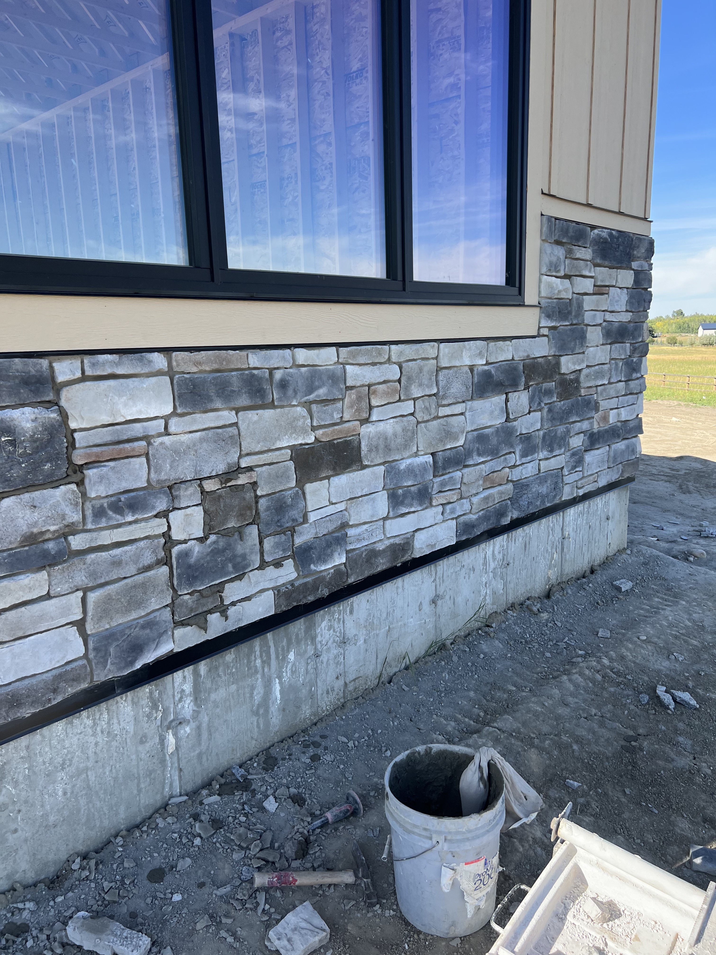 Natural stone wainscot installation around a window on a Calgary home