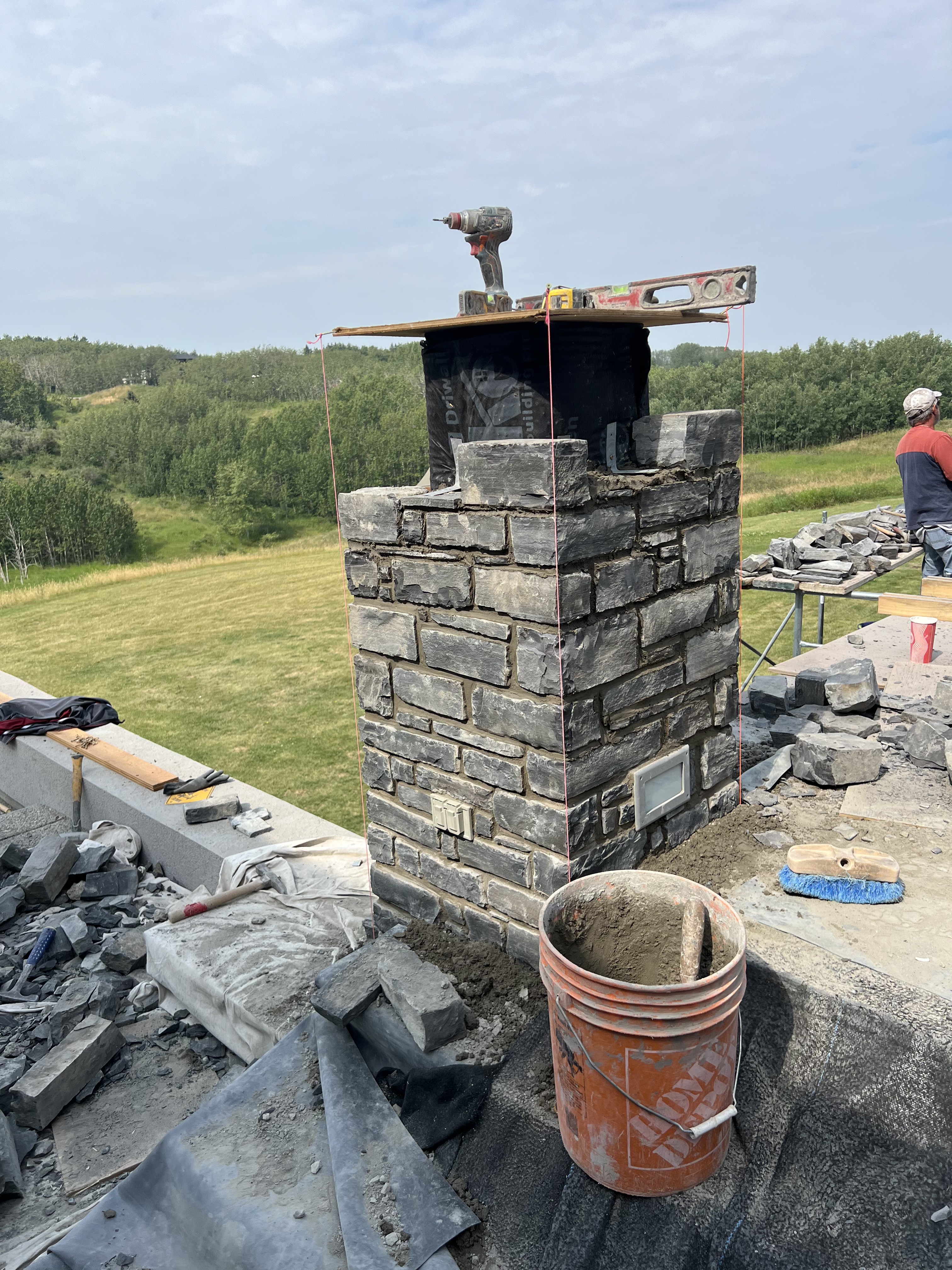 Stone chimney rebuild on a Calgary rooftop