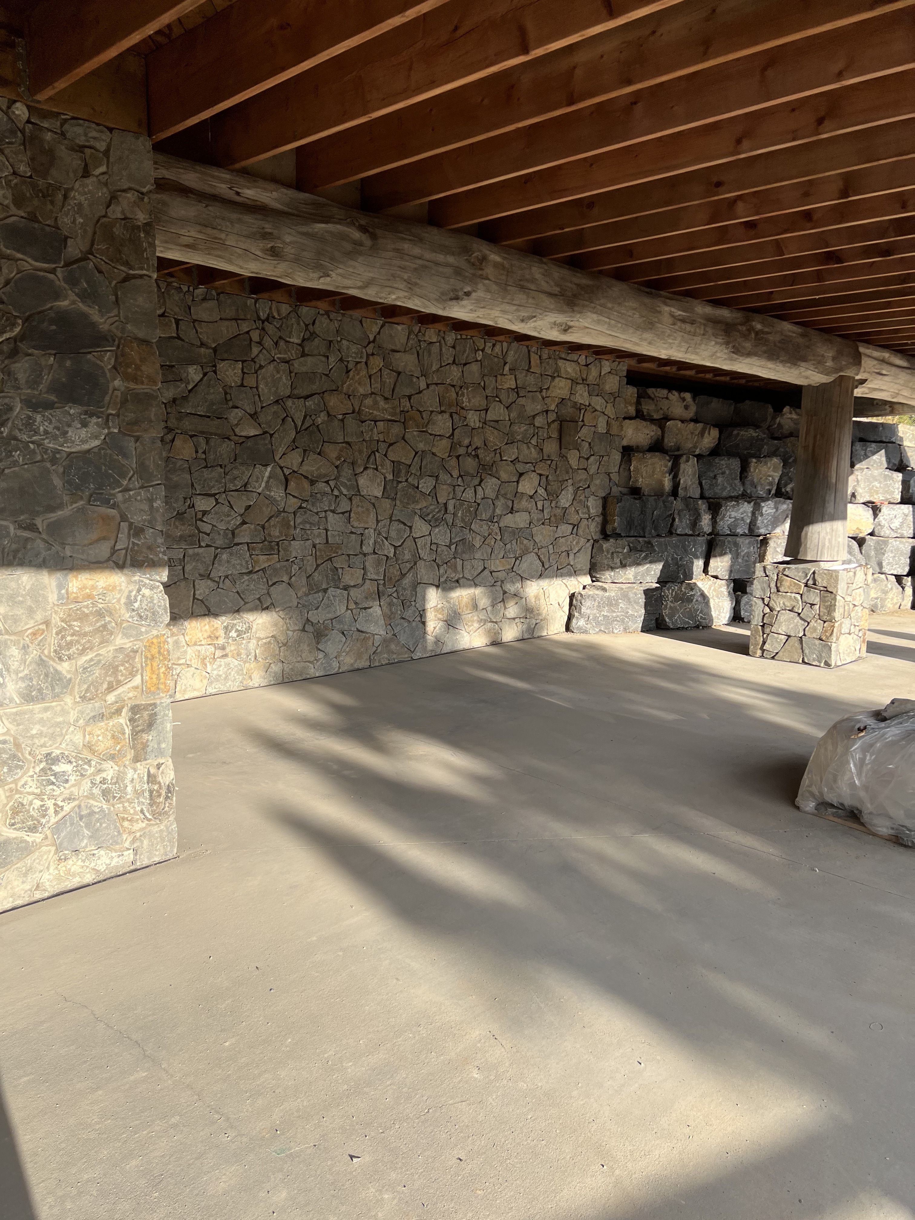 Tumbled stone wall under log home deck